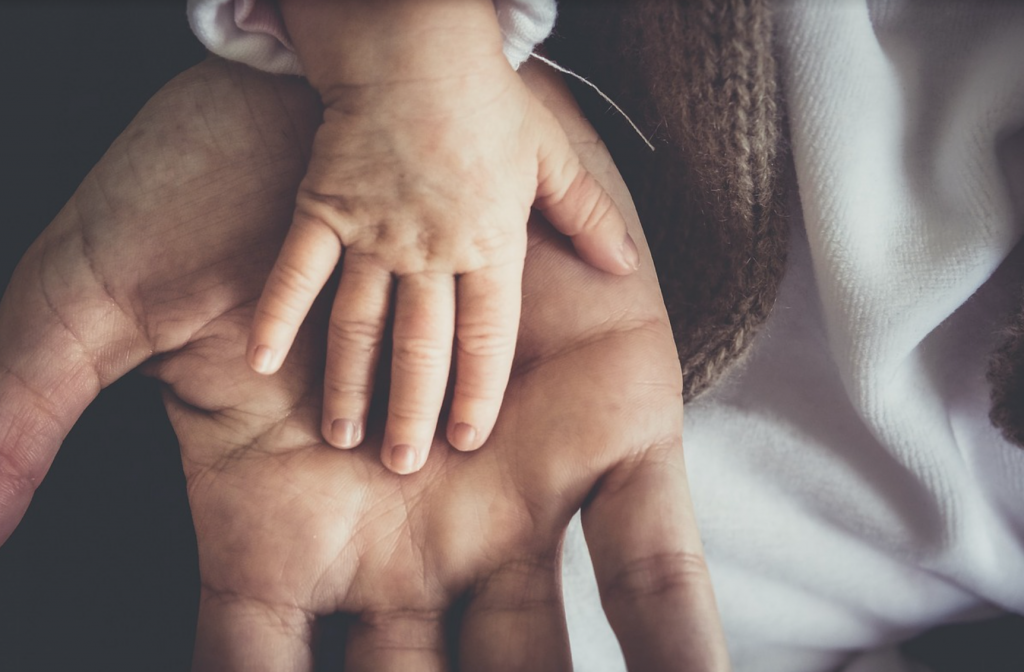 Father and baby's hand.